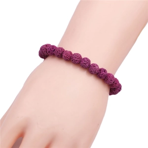 Detail of 8mm purple lava rock beaded bracelet worn on wrist with natural stone texture