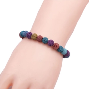 Close-up of 8mm multicolored natural lava stone beads bracelet on a wrist with porous texture