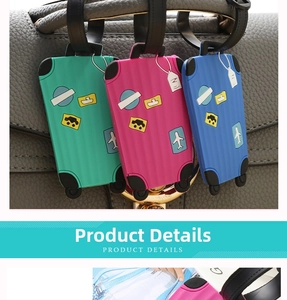 Close-up of colorful PVC luggage tags with cartoon motifs hanging on a gray leather bag