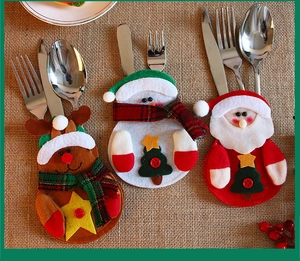 Detail of Christmas cutlery holders featuring Santa, snowman, and reindeer on burlap background