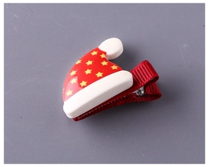 Vista dettagliata di un fermaglio per capelli a cappello di Natale rosso con stelle e pompon