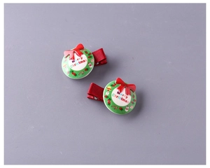 Dettaglio di fermagli natalizi con scritta Merry Christmas e fiocchi di nastro rosso