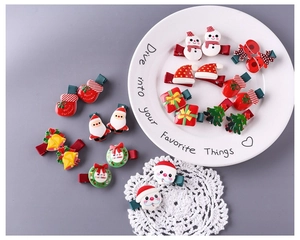 Dettaglio flat lay di fermagli natalizi in resina con motivi Babbo Natale e pupazzo