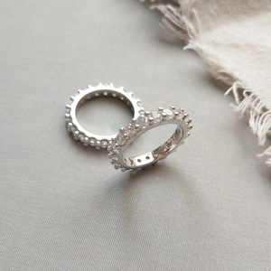Detailed close-up of S925 sterling silver eternity bands with clear cubic zirconia stones