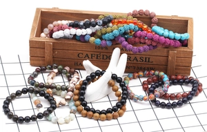 Detail view of 8mm natural lava rock and tiger eye beaded bracelets in vintage wooden box