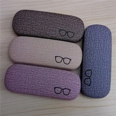 Detail view of linen texture eyeglass cases in four colors on a light wood background