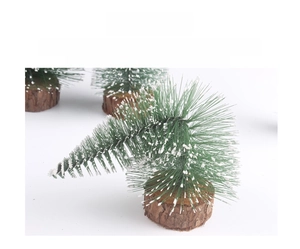 Detail of mini snowy Christmas tree with green needles and a rustic wooden round base