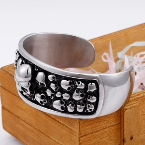 Silbernes Vintage-Punk-Totenkopf-Armband im breiten offenen Stil auf einer Holzkiste