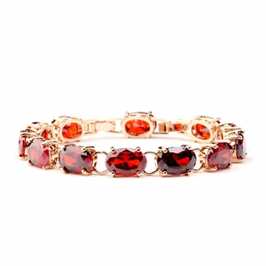 Elegant gold bracelet with oval red gemstones in claw setting for women