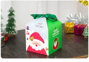 Dettaglio scatola regalo di Natale con Babbo Natale e nastro verde per dolci festivi