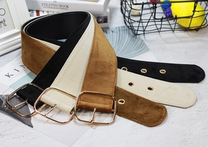 Detail of velvet waist belts with large gold buckles in black, cream, and caramel colors