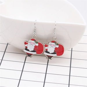 Detailed view of Santa Claus earrings with sunglasses on a white ceramic display