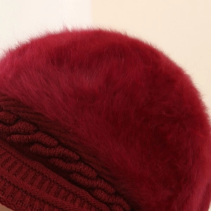 Vista dettagliata della texture in pelo di coniglio e maglia a trecce di un cappello bordeaux