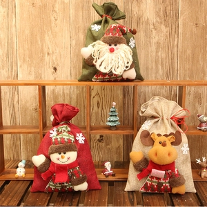 Detailed view of three burlap Christmas candy bags with 3D Santa, snowman and reindeer dolls