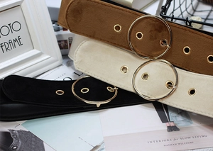 Close-up of suede waist belts in brown, beige, and black with gold round buckles