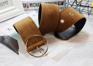 Detailed view of caramel velvet belt with a large gold round buckle and metallic eyelets