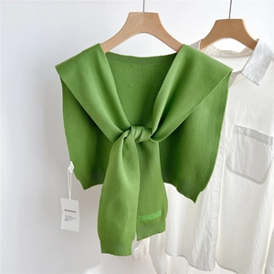 Détail du châle en tricot vert herbe avec broderie Doria Dore et texture côtelée fine