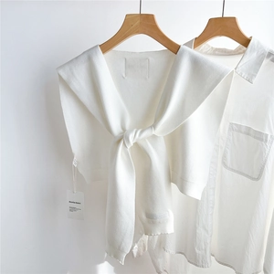 Détail du châle en tricot blanc avec broderie Doria Dore et texture délicate