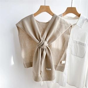 Close-up of beige 100% wool knitted shawl texture and detailed fabric label