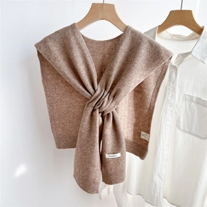 Detailed view of camel knitted 100% wool shawl draped over a classic white shirt