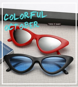 Close-up of retro cat-eye sunglasses in red with silver lenses and black with blue lenses