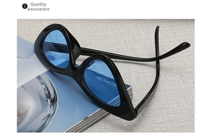 Detail view of cat eye sunglasses with black glossy frames and blue tinted lenses
