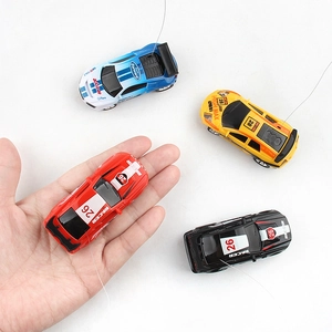Mini RC cars in four colors blue yellow red black showing compact size on palm