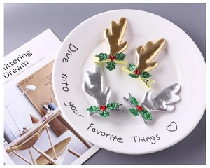 Détails de barrettes bois de renne scintillantes or et argent sur une assiette décorative