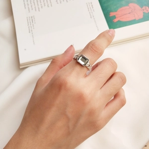 Close-up of S925 silver chain ring with square green zircon on a model's hand