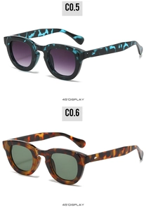 Detail view of oval tortoiseshell sunglasses with metal arrow hinges and gradient lenses