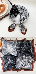 Macro detail of paisley print silk scarf with black white patterns and brown edges