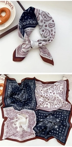 Detail view of navy blue and white paisley bandana scarf with artistic prop arrangement