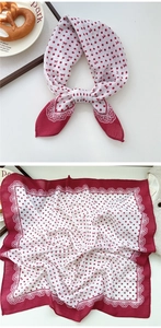 Close-up of red and white polka dot silk scarf with bow patterns and lace edges