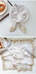 Close-up of the elegant lace border and polka dot pattern on a cream silk square scarf