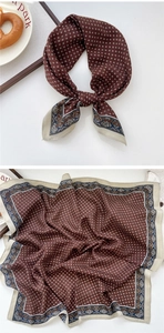 Detailed view of dark red paisley silk scarf with vintage floral borders and bow tie styling