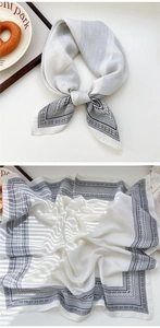 Detail of white satin bandana with black paisley border styled on a table