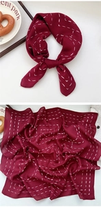 Close-up of burgundy square scarf with white dotted stitching and soft fabric texture