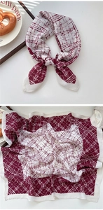 Detail of red and cream paisley square scarf tied in a bow with light silk texture