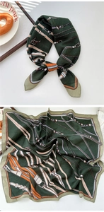 Detail of elegant dark green silk scarf with chains, buckles and strap patterns