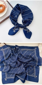 Detail of navy blue silk square scarf featuring silver chain and architecture patterns