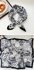 Close-up of black and white paisley silk scarf with elegant wide border details