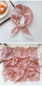 Close-up of salmon pink paisley scarf tied as a soft hair accessory and laid flat