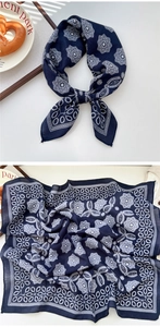 Detailed pattern of navy paisley cotton scarf shown with French afternoon tea prop setting