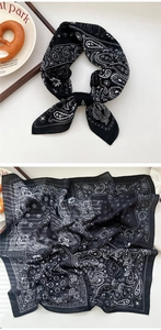 Close-up of black and white paisley pattern square scarf with elegant knot styling