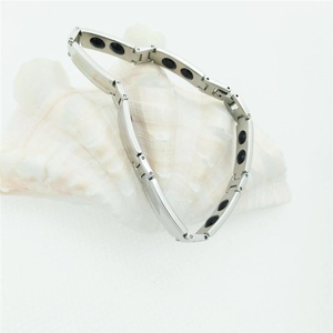 Dettaglio del bracciale magnetico argento con inserti neri su una conchiglia