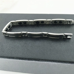 Dettaglio del bracciale magnetico in argento con doppi inserti neri su pelle scura