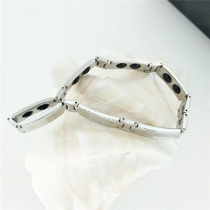 Polished silver stainless steel energy bracelet with magnetic therapy stones on shell