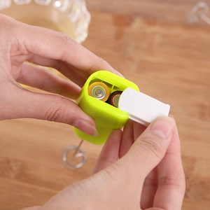 Handheld electric milk frother in lemon green with dual AA battery compartment display