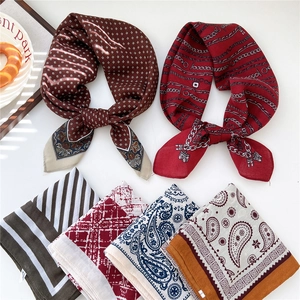 Set of six colorful paisley and striped silk scarves displayed on a white background