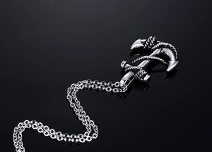 Detailed close-up of a vintage silver anchor pendant on a sturdy metal necklace chain